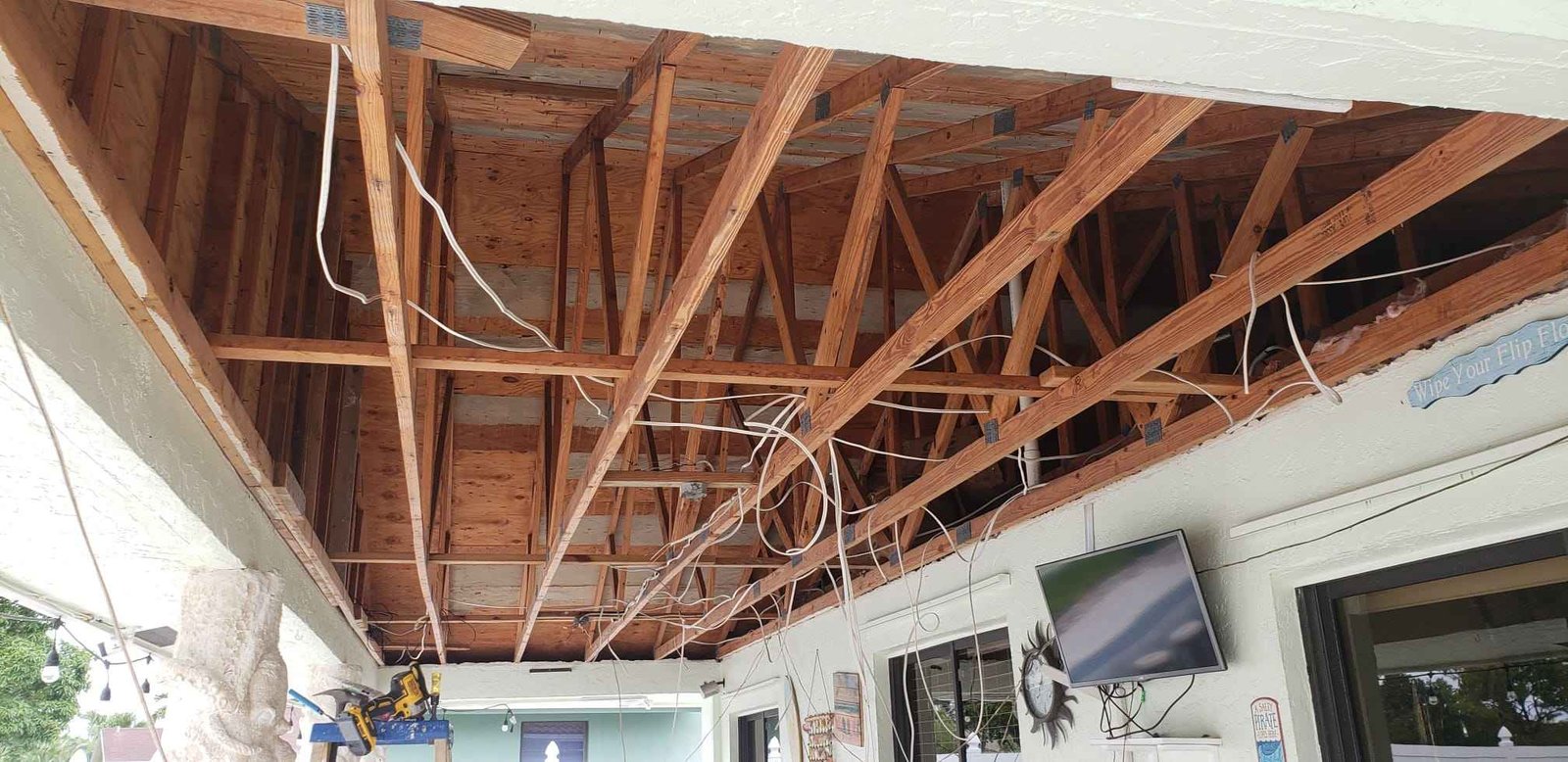 Patio roofing removal with exposed framing during a renovation